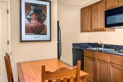 Compact kitchenette with dining table and cabinets in a suite at Hilton Santa Fe Buffalo Thunder