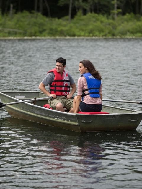 Couple observing the surrounding while enjoying a relaxing rowboat experience near Cove Pocono Resorts