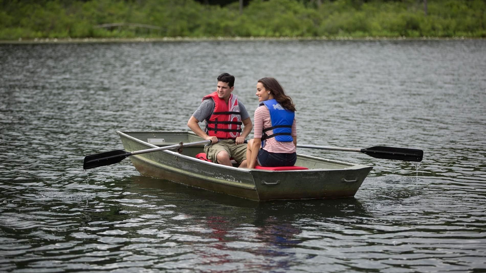 Couple observing the surrounding while enjoying a relaxing rowboat experience near Cove Pocono Resorts