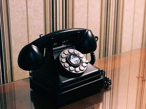 A vintage telephone on wooden surface at Heritage House Resort