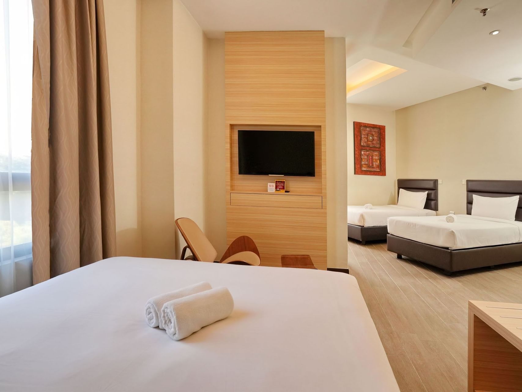 TV lounge area by the beds in Deluxe Quad with wooden floors at Cititel Express Ipoh