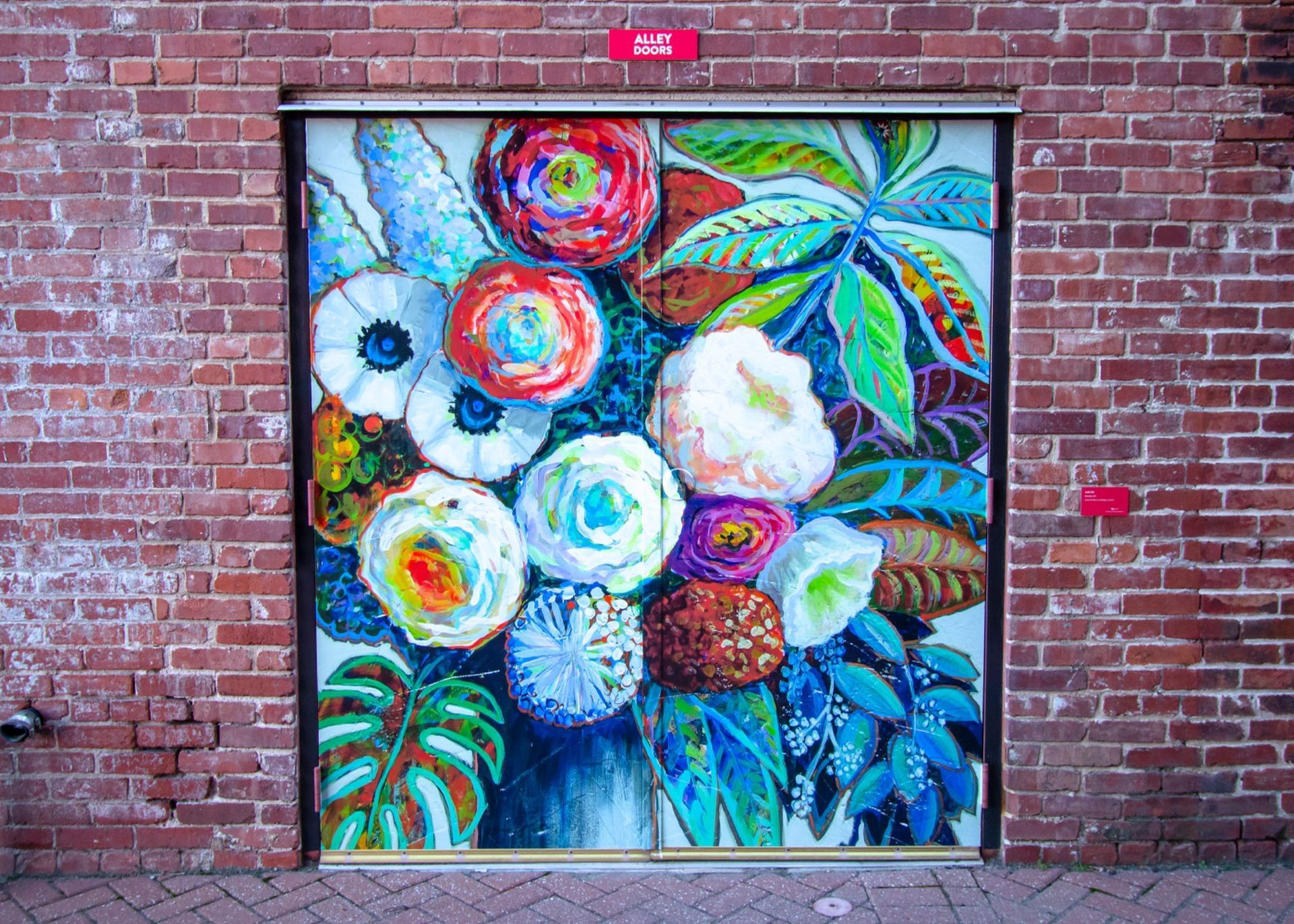 A colorful mural of flowers on a brick wall.