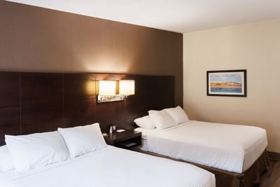 Double beds with a brown accent wall in Royalty Room Two Queen at Rodd Royalty, prime Charlottetown accommodations