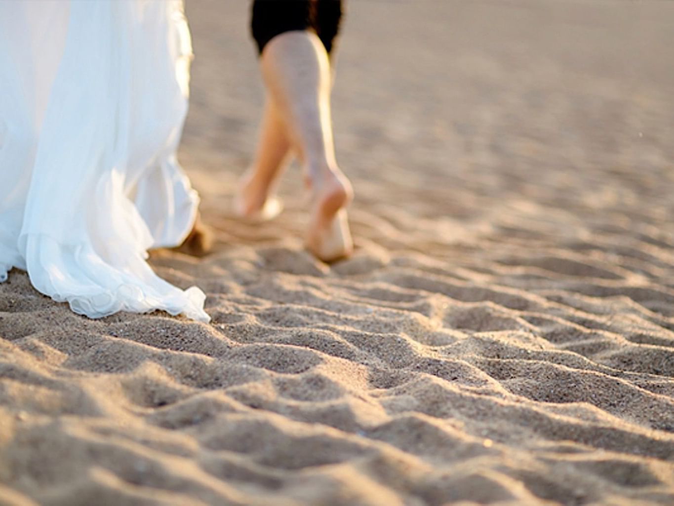 Bride & groom walking on sand at Casa Colonial Beach and Spa