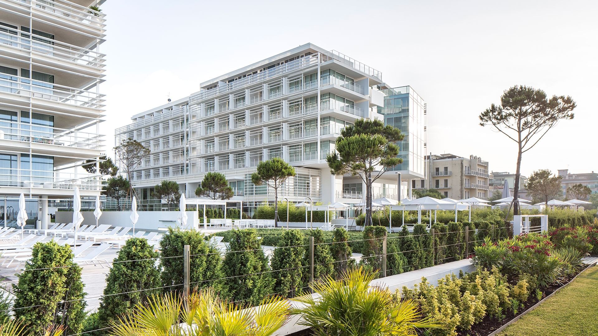 Exterior view of Falkensteiner Hotel & Spa Jesolo with landscaped garden and sun loungers