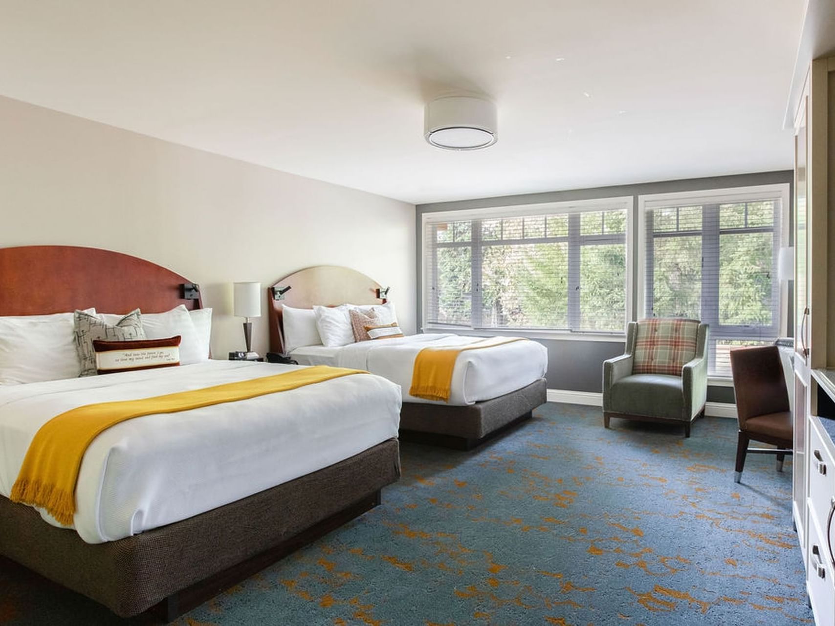 Two beds by the window overlooking the forest in Creekside Double Queen ADA at Alderbrook Resort & Spa