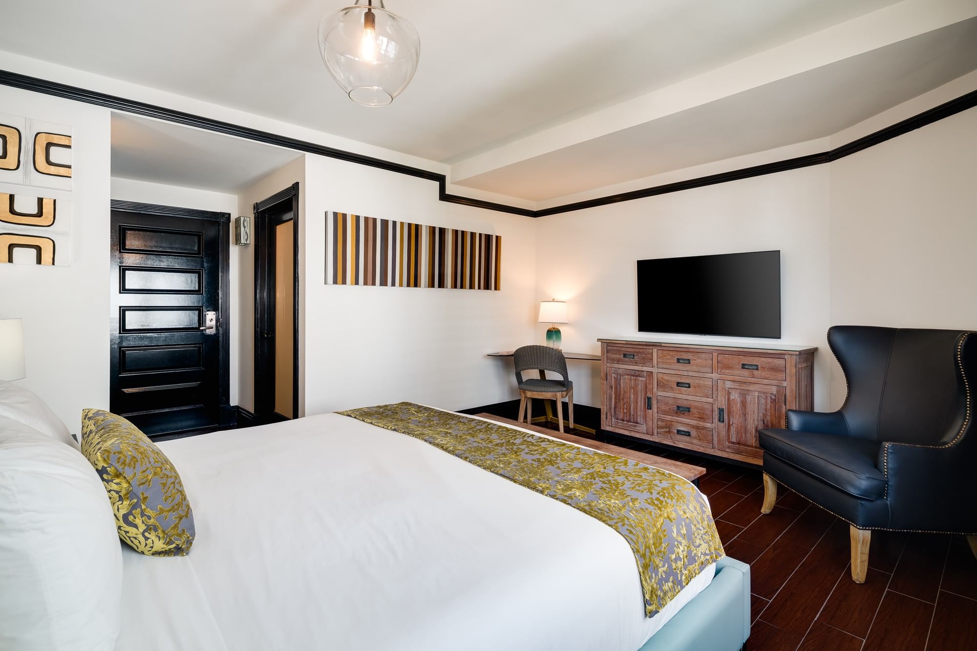 A hotel room with a bed, TV, desk, and chair.