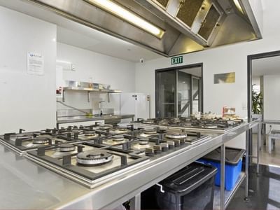 Modern kitchen with stainless steel countertops and gas stoves at Student Living Auckland - Beach.