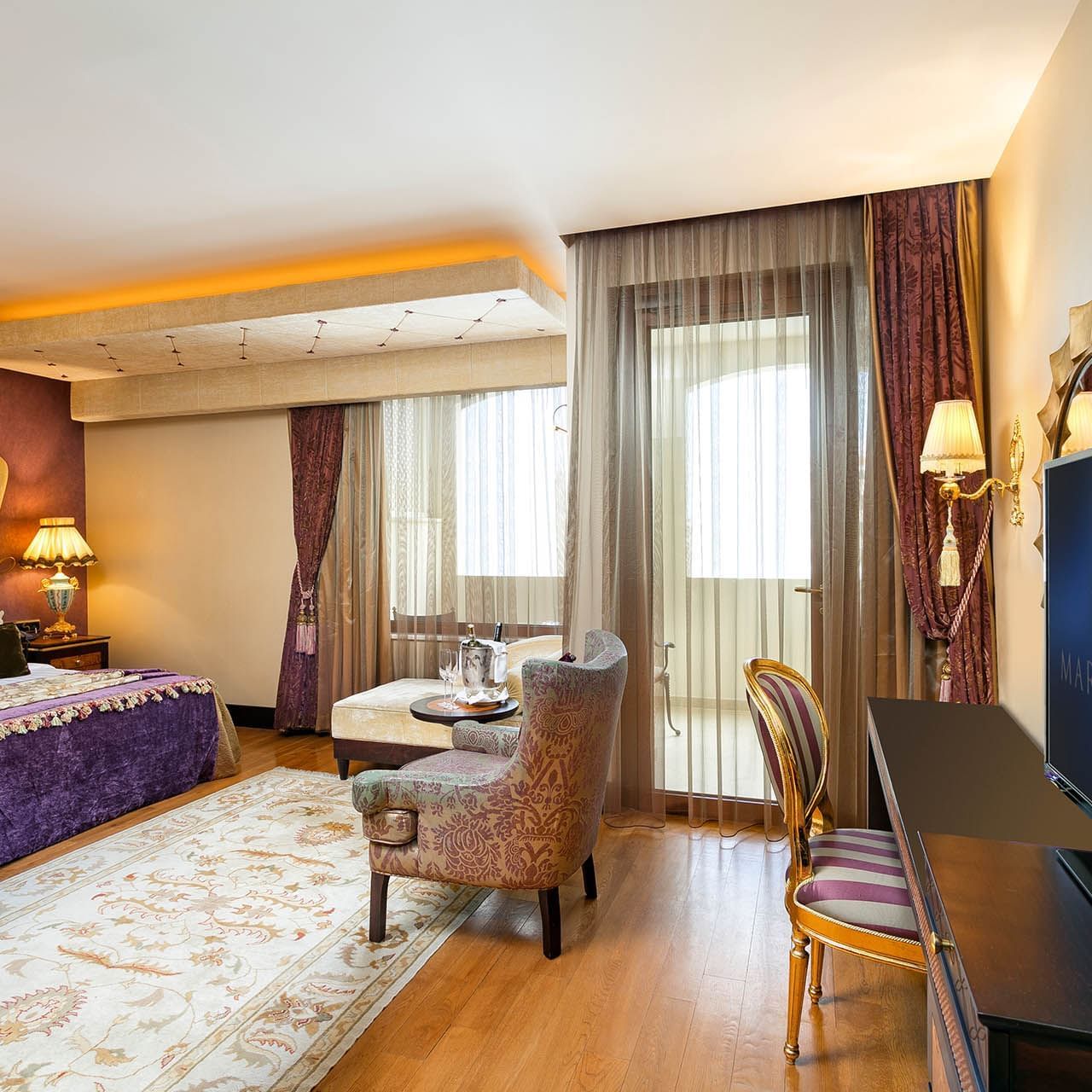Comfy bed and lounge in Premium Sea/Pool View Room at Titanic Mardan Palace