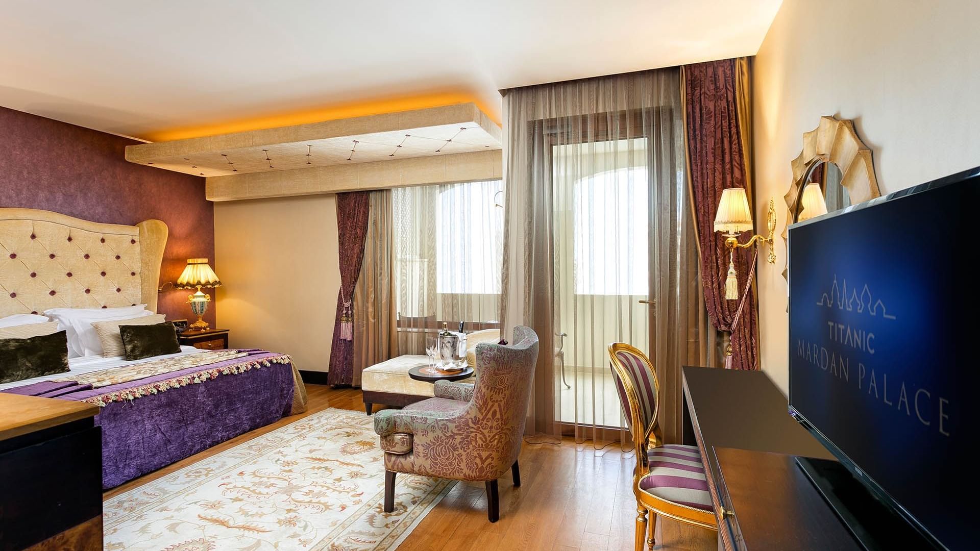 Comfy bed and lounge in Premium Sea/Pool View Room at Titanic Mardan Palace