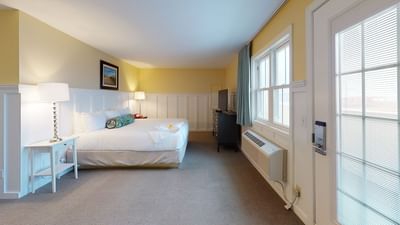 TV facing bed with nightstands and carpet flooring in Cafe King Suite at The Hotel Maria