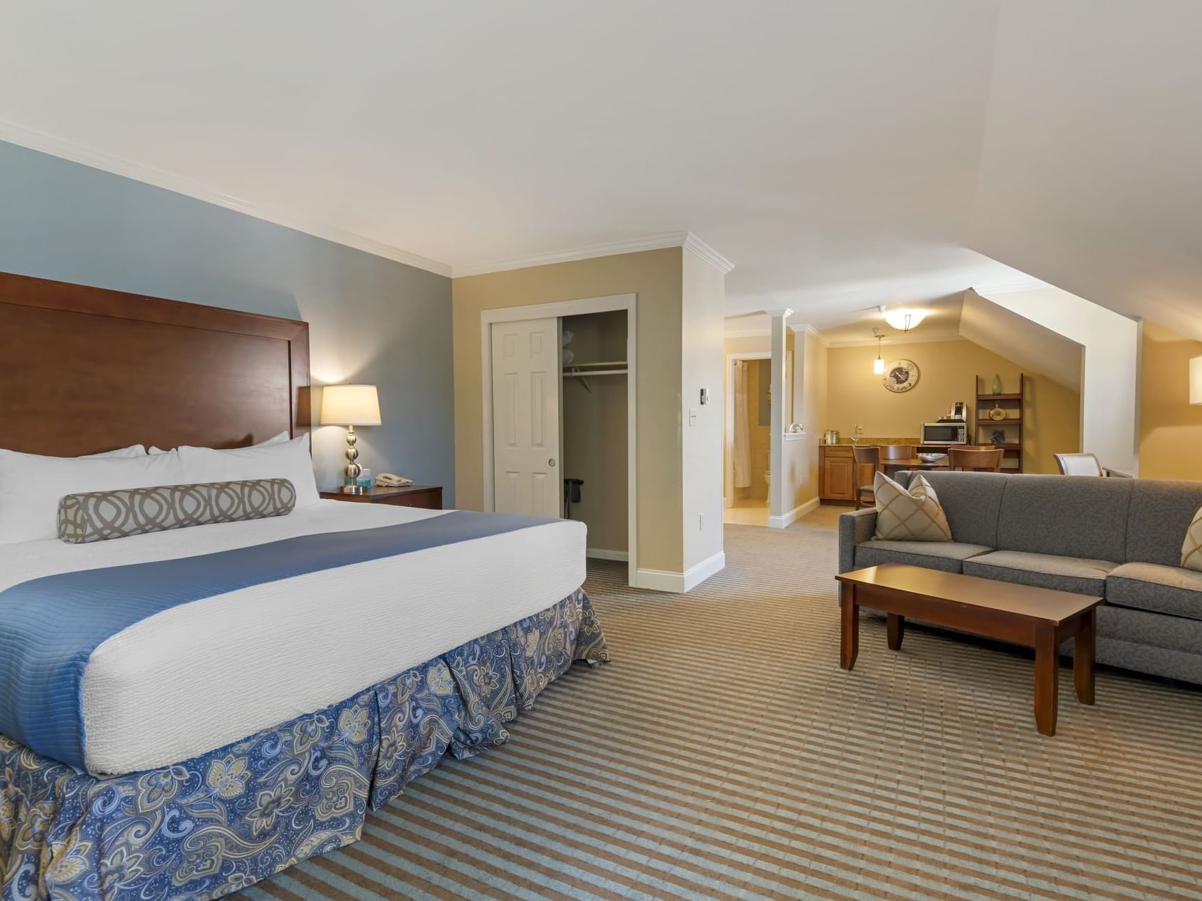 Seating area & closet by the bed in Deluxe King Fireplace Room at Union Bluff Hotel