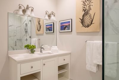 Bathroom vanity with mirror & towel rack in King Premiere Palm at Retro Suites Hotel