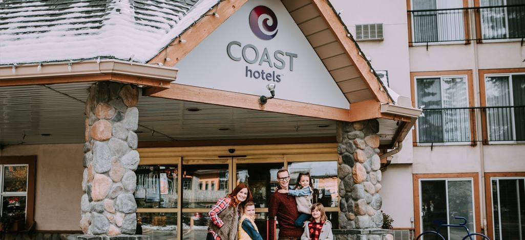 A family leave the Coast Canmore Hotel & Conference Centre to shop locally.