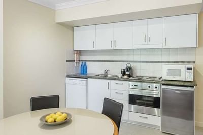 Kitchen & dining table in an apartment at Nesuto Hotels
