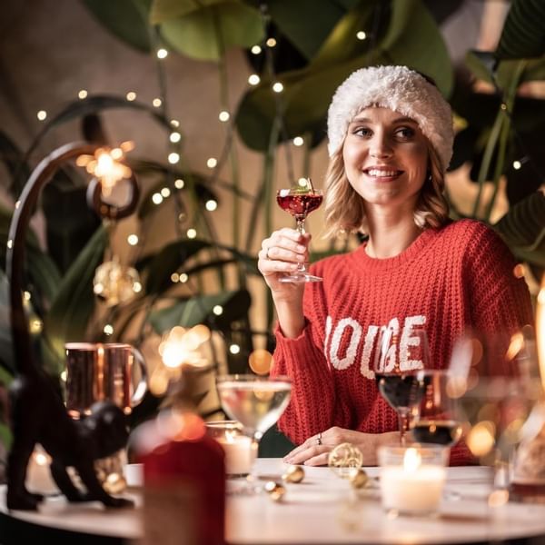 A girl smiling while tasting wine at Falkensteiner Hotels