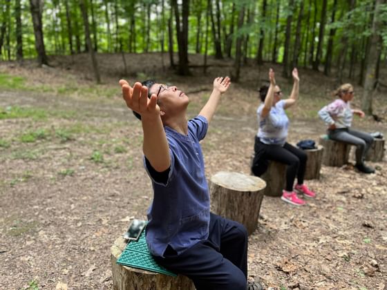 People meditating in the woods near Honor's Haven Retreat