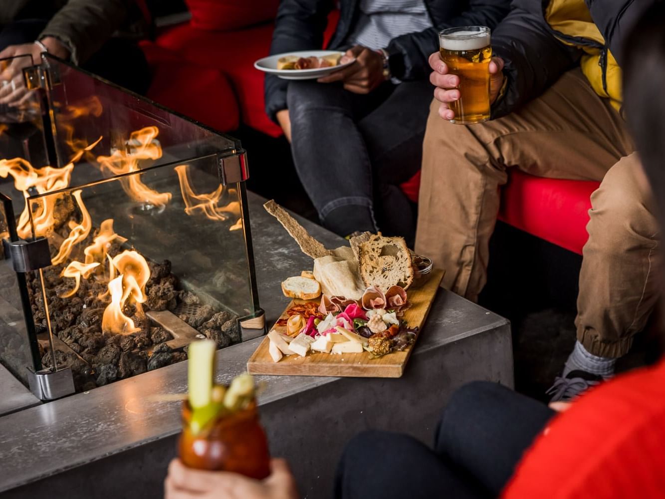 People enjoying beverages by a fireplace at Nita Lake Lodge