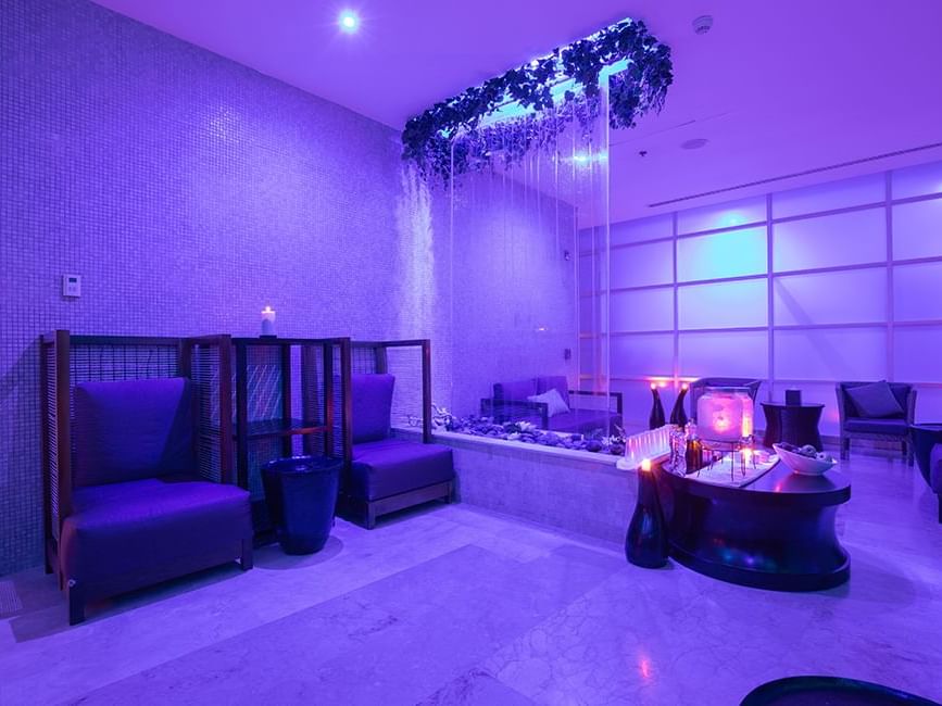 Feel Harmony Spa lounge with a waterfall wall feature, mood lighting, and relaxing seating area at Live Aqua Cancún