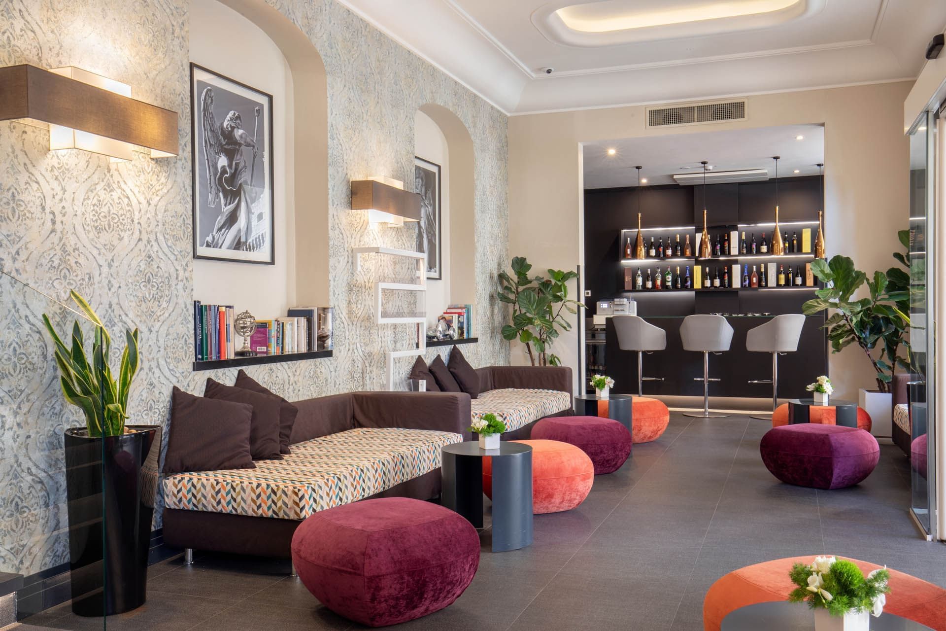 Stylish lounge area featuring modern seating, vibrant poufs, bookshelves, and a bar at The Republic Hotel