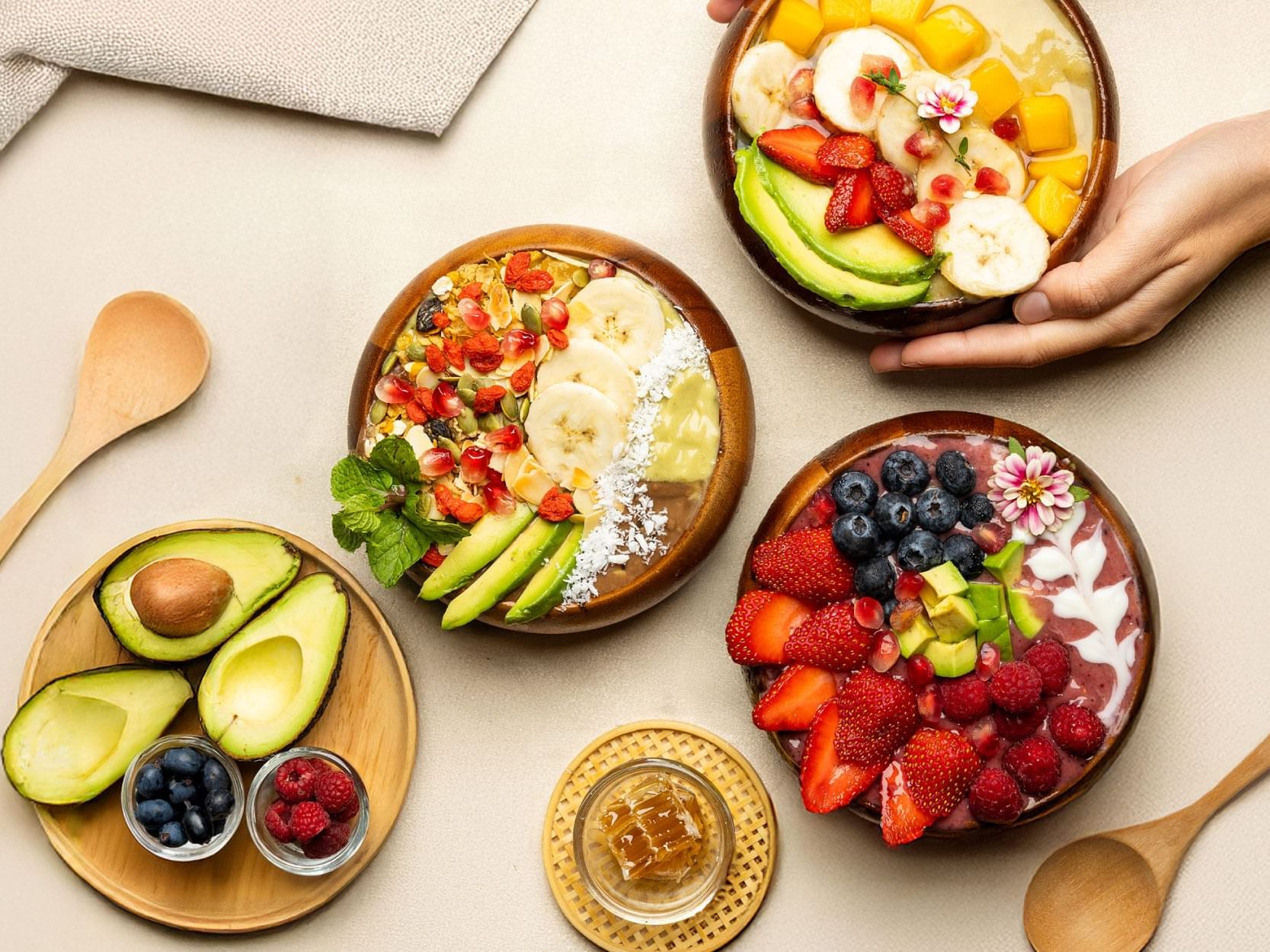 A table features three bowls containing a variety of fresh fruits and vegetables, highlighting their natural beauty.