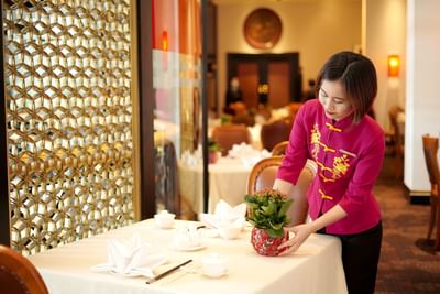 A girl cleaning the table in dining area at Hanoi Daewoo Hotel