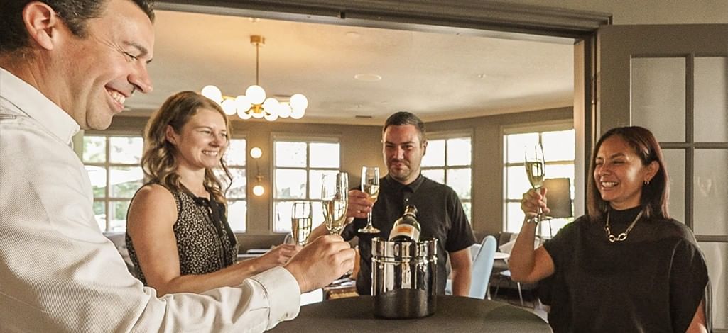 A team enjoys champagne at the welcome happy hour to their corporate retreat in Canmore.