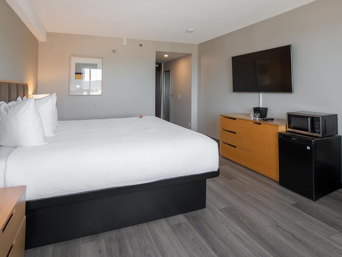Hotel room with a king bed, TV, microwave, and mini fridge