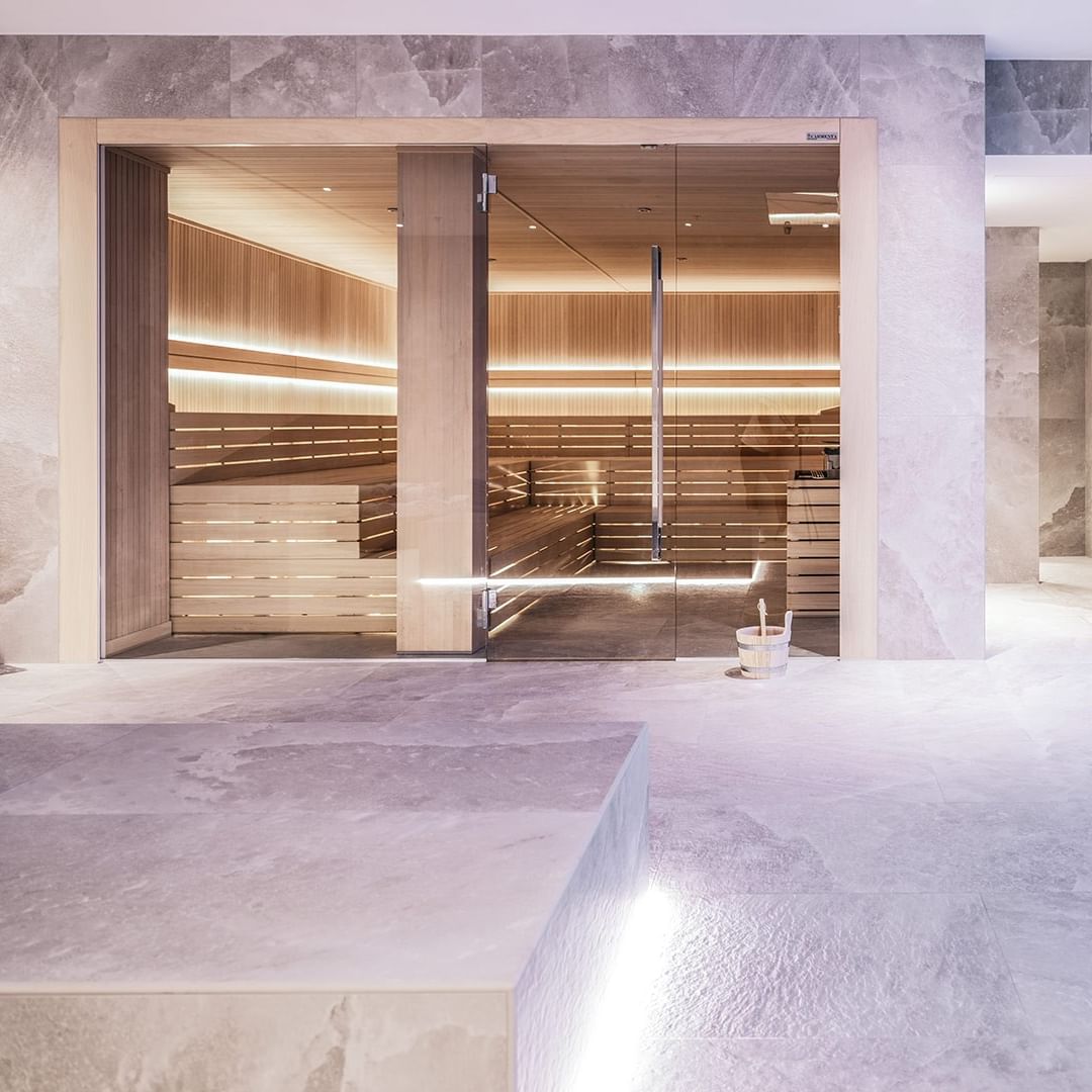 Interior of a modern spa with glass doors, wooden benches, and a clean, minimalist design.