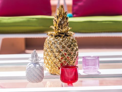 Mesa del bar Delfines con dos esculturas de piña y candelabros de cristal rosa y rojo en Hacienda del Mar Los Cabos