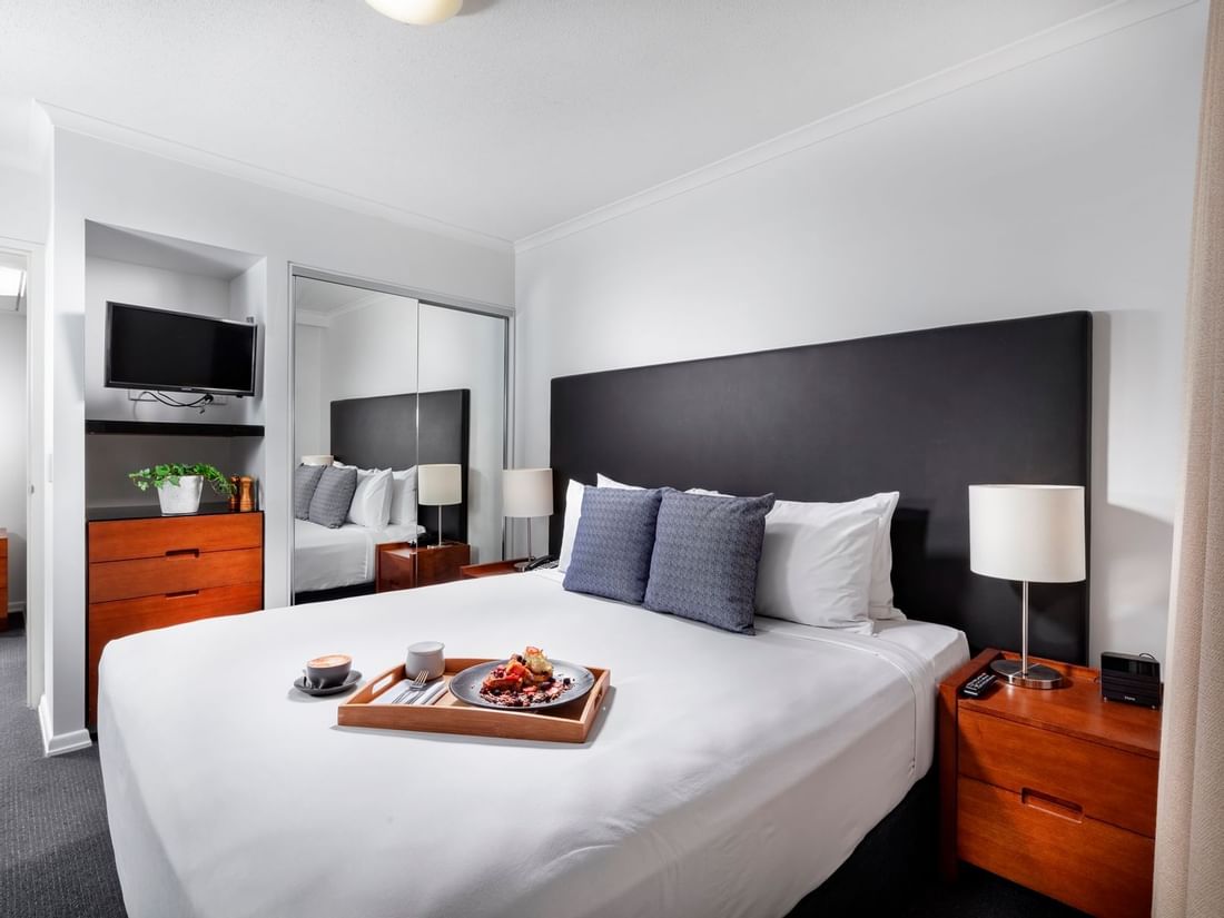 Food tray on the bed at Sebel Suites Brisbane