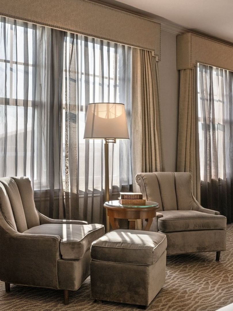 Deluxe King with Two plush armchairs by a round table under a tall lamp in Deluxe King at Warwick Melrose Dallas