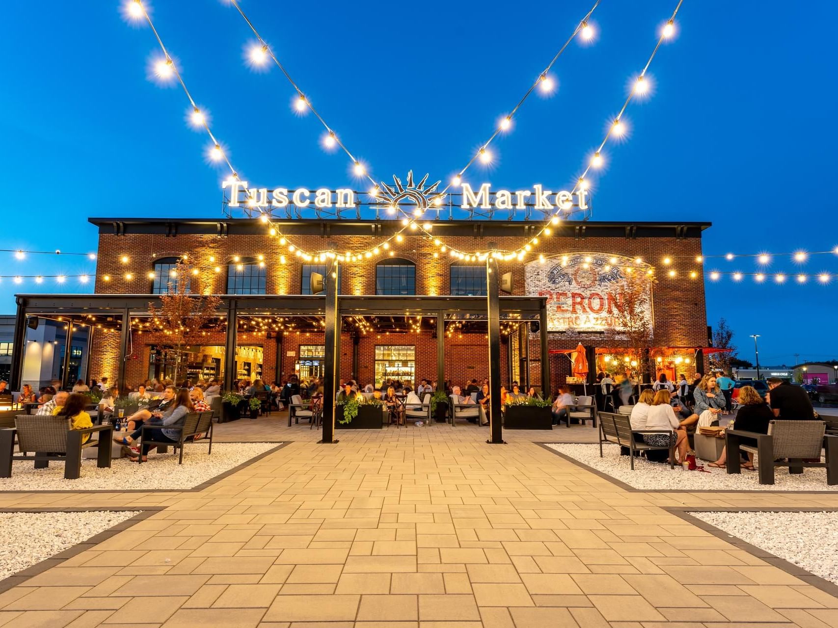 People lounging by the open space in Tuscan Market near The Artisan Hotel at Tuscan Village