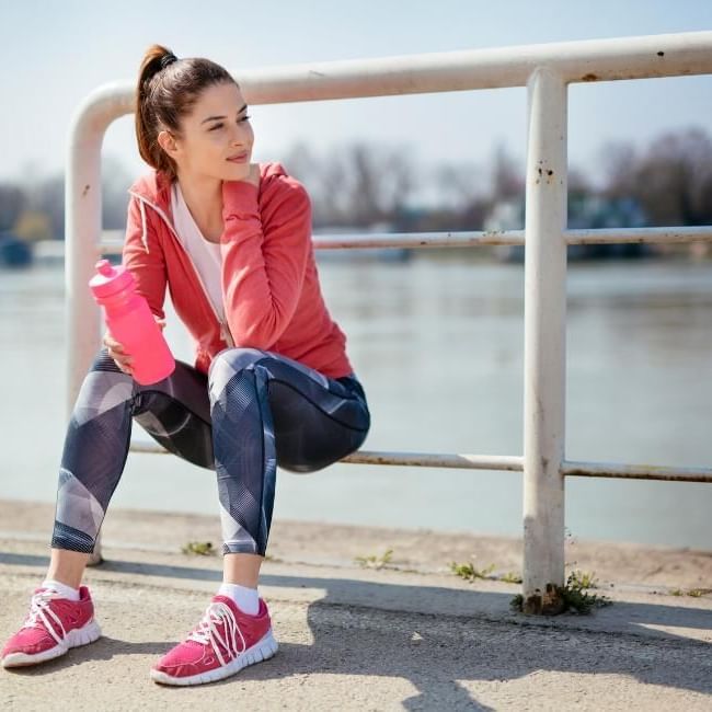 How Important Are Rest Days in Your Workout Schedule featuring a woman at rest after a run