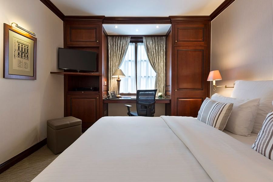 Slaapkamer met bureau en comfortabel bed bij Warwick Grand-Place Brussels.