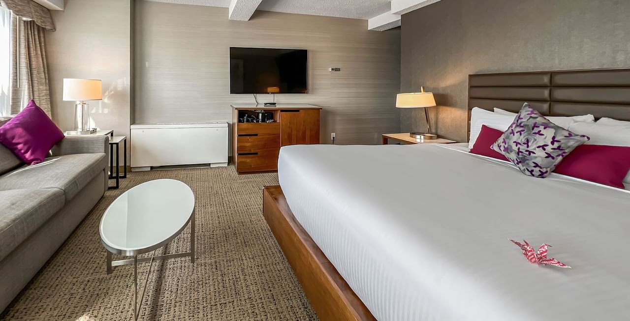 Hotel room with bed, TV, couch, and table