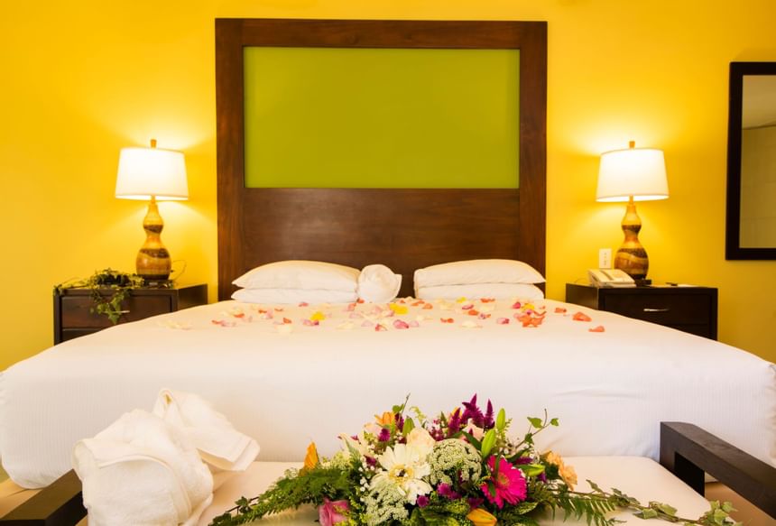 A bed decorated with flower petals in a room at Fiesta Resort