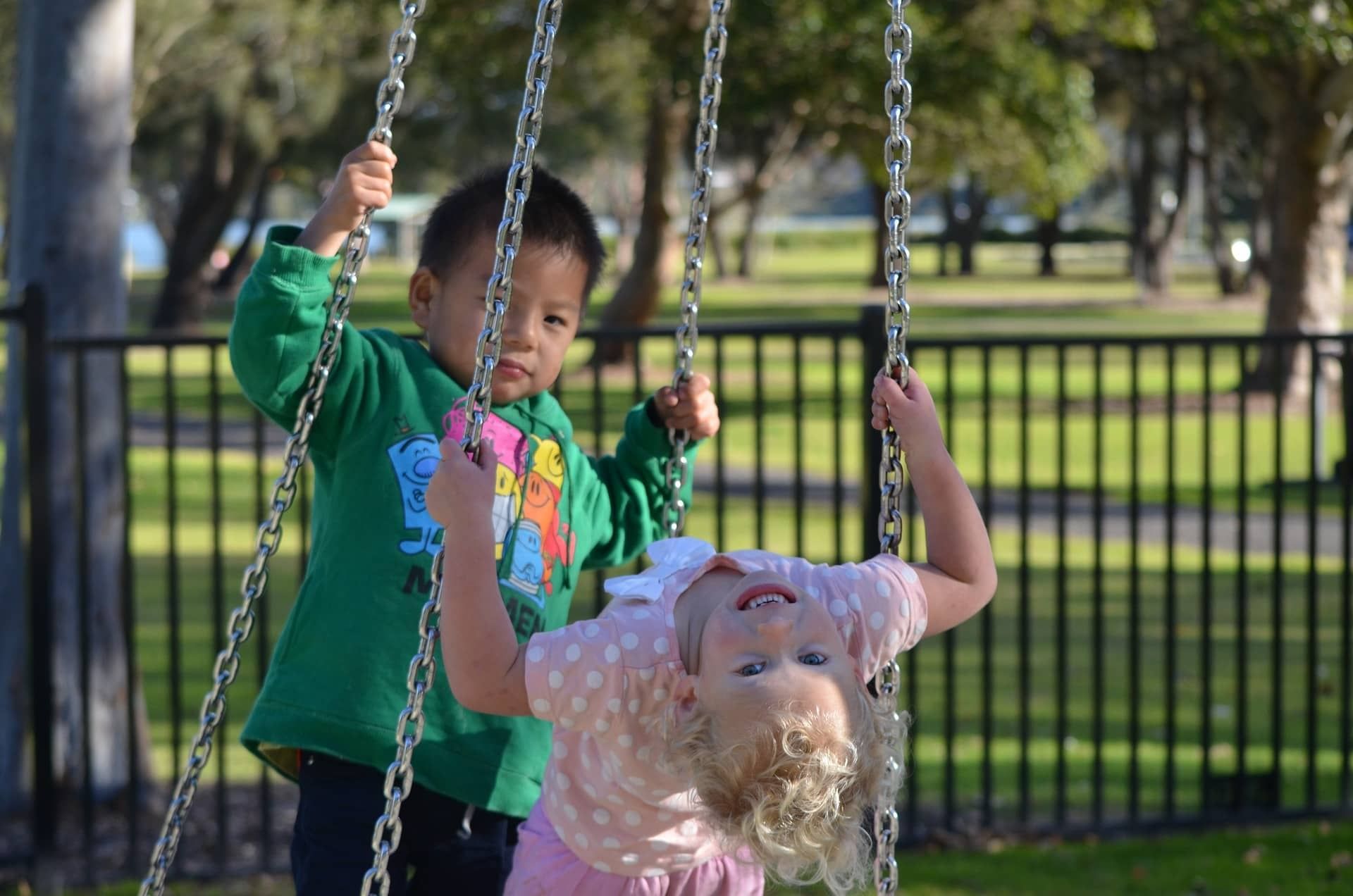 Two children play on a playground swing at Rosen Inn Universal