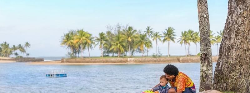 Mother and child playing on a blanket by the beach at The Naviti Resort - Fiji in Korolevu
