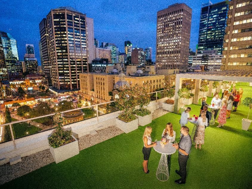 Rooftop gathering with people chatting in Soiree Deck at Sofitel Brisbane Central