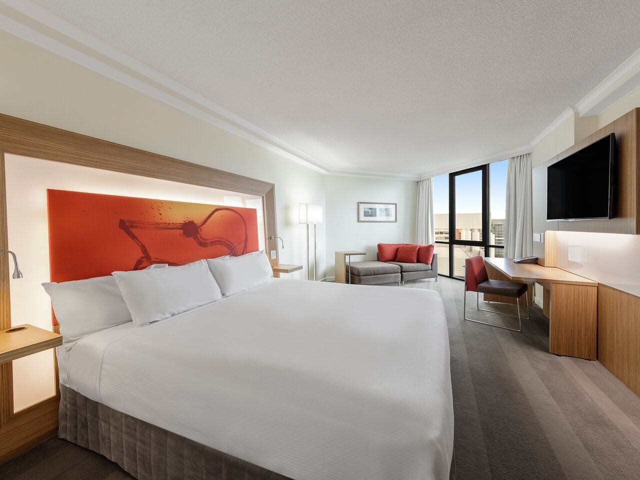 Bed & sofas by the window in Premier King Room at Amora Hotel