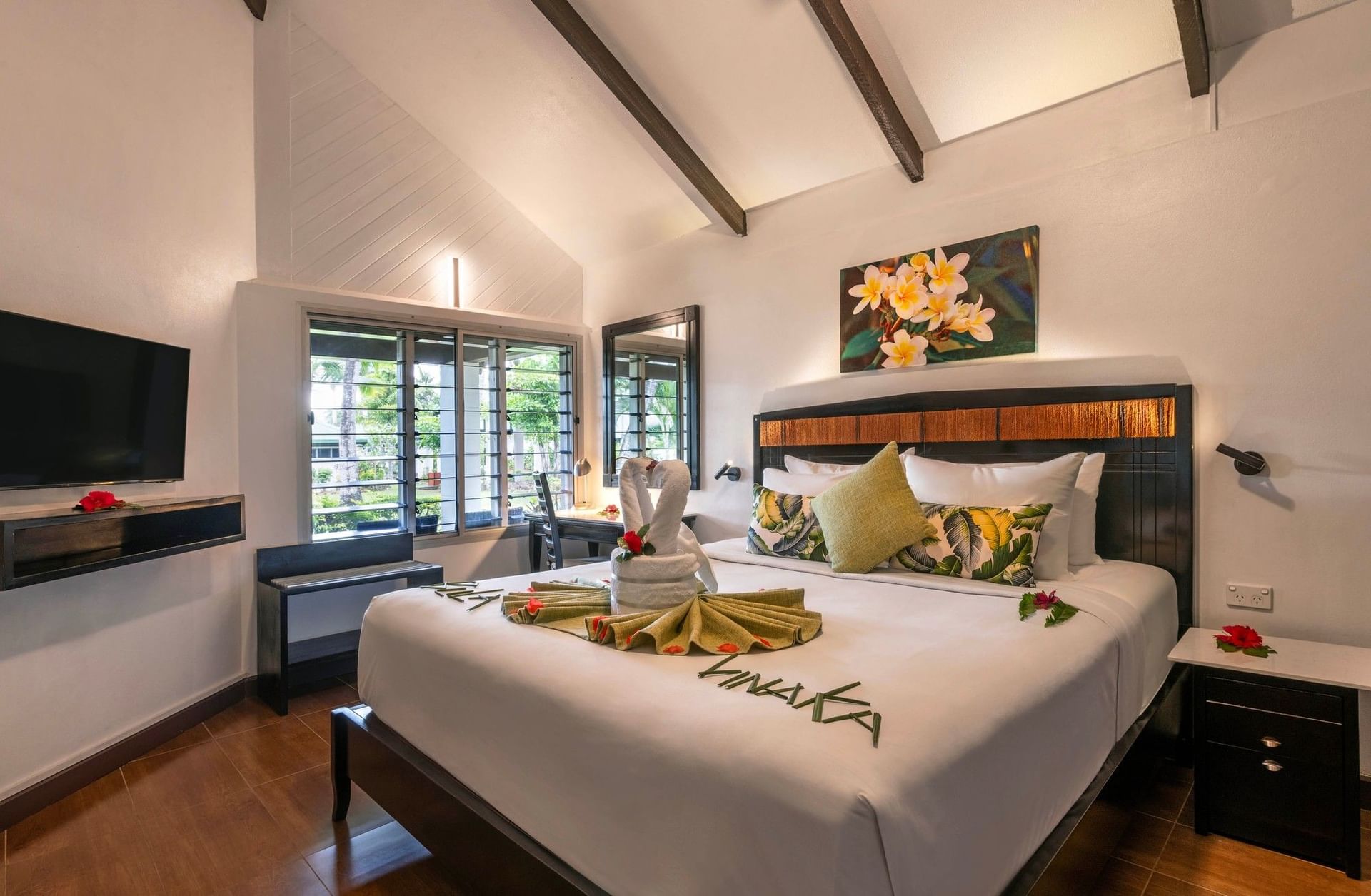 Ornate towel swan display on a master bed featuring plumeria floral art in One Bedroom Villa at TokaToka Resort Nadi Fiji