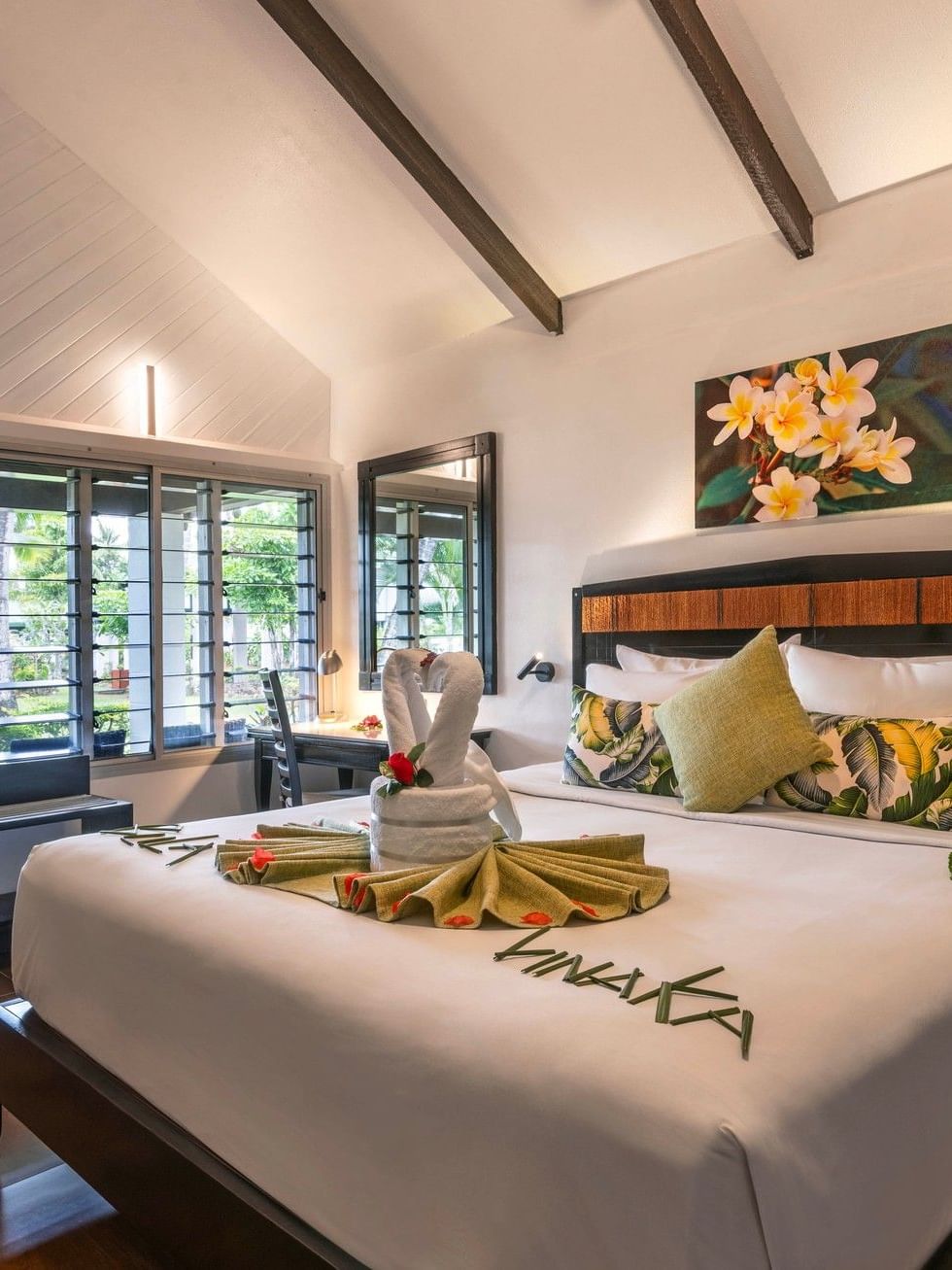 Cozy bedroom with white bedding and tropical decor in One Bedroom Villa at Tokatoka Resort Nadi.