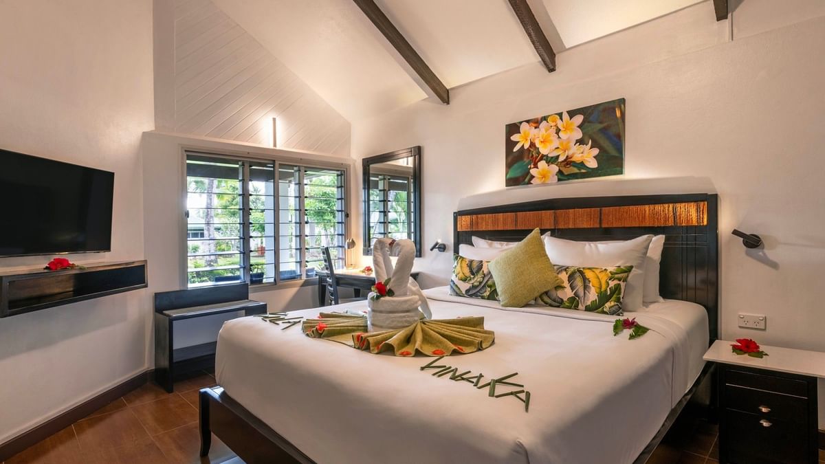 Cozy bedroom with white bedding and tropical decor in One Bedroom Villa at Tokatoka Resort Nadi.