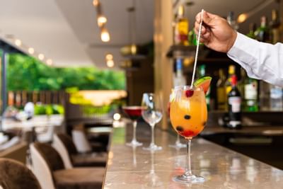 Un bartender poniendo un pitillo en un cocktail en los hoteles Bluedoors 