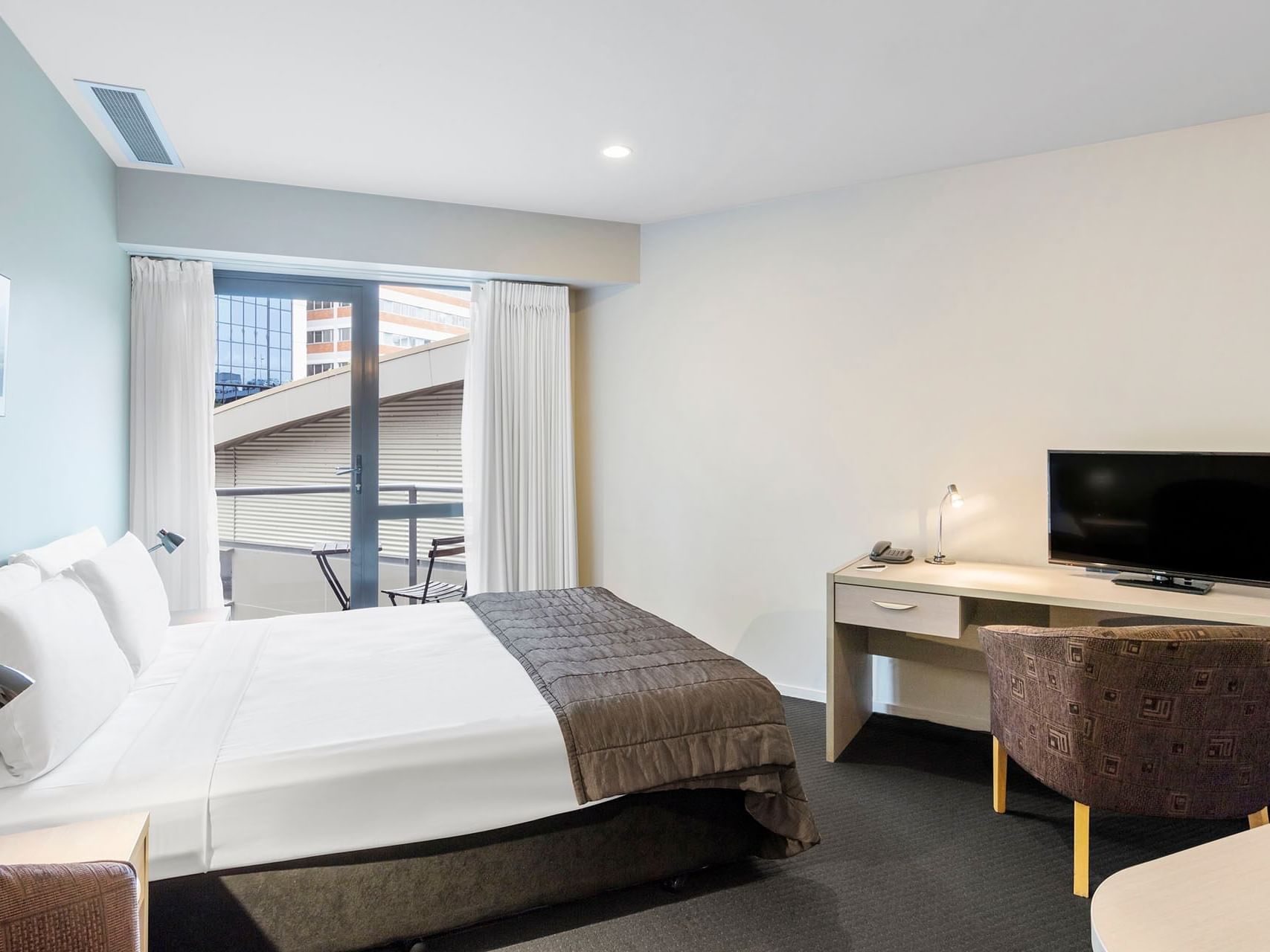 Bed & desk in Studio Room at Hotel Grand Chancellor