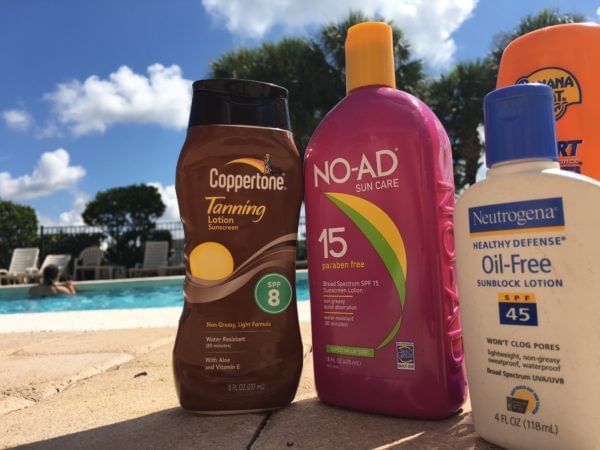 Three sunscreen bottles by a poolside at Lake Buena Vista Resort Village & Spa