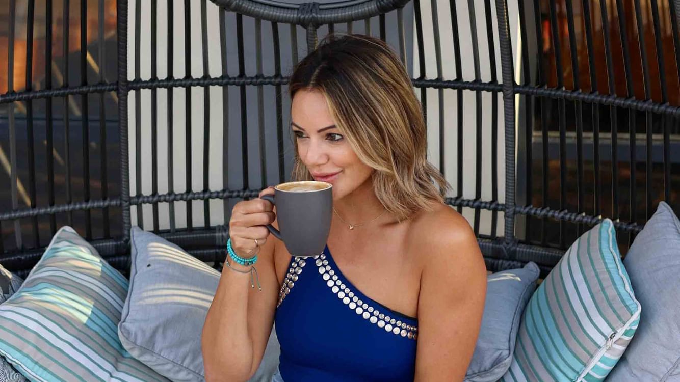 lady having a warm coffee and full breakfast spread