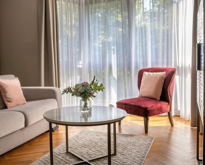 Living area with plush seating, outdoor views and wooden floors in Premium Suite at Warwick Reine Astrid - Lyon