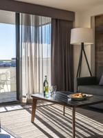 Living area with a sofa by a coffee table under a floor lamp in Premier Junior Suites at Warwick Denver